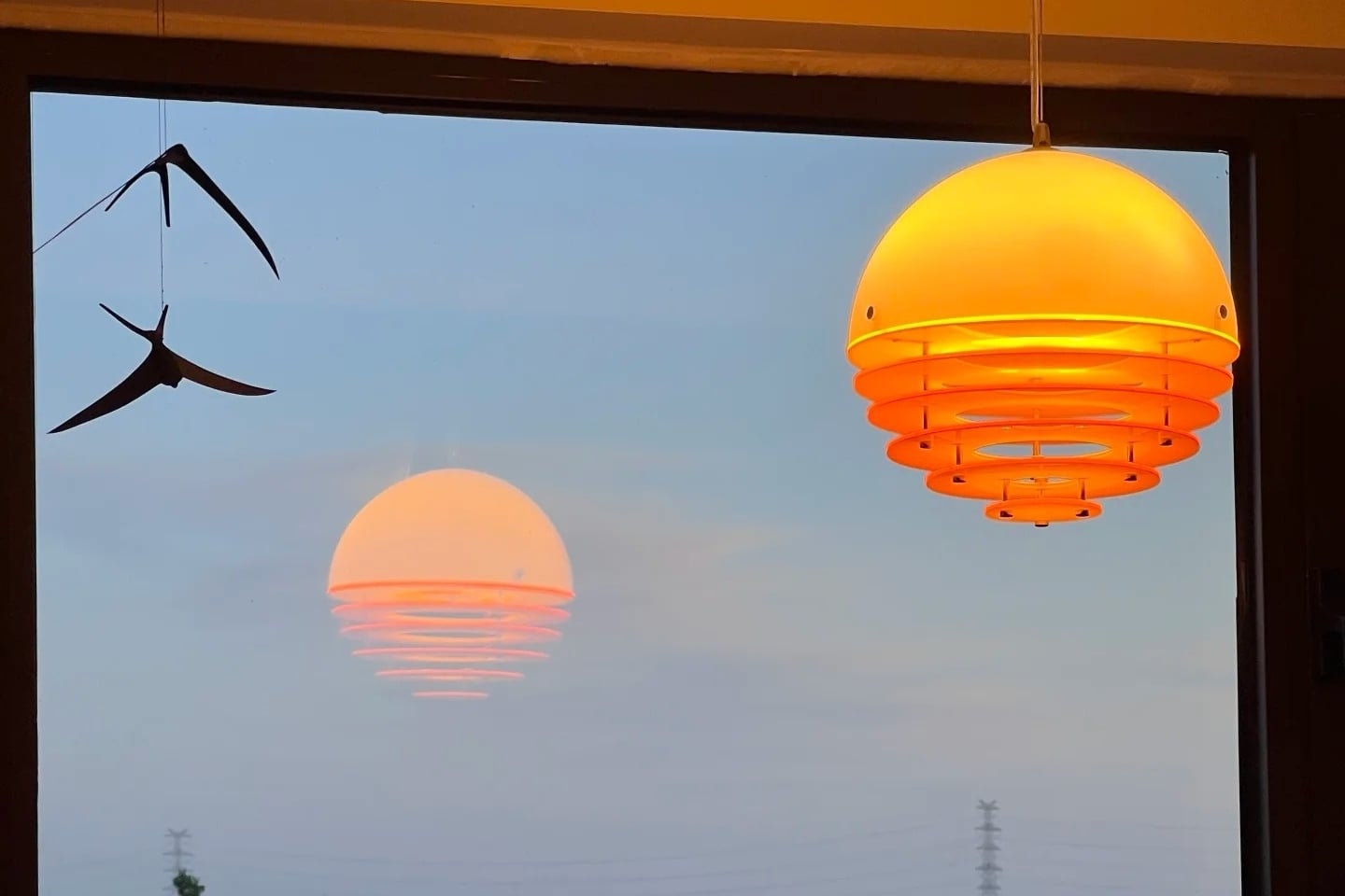 Lampa o zachodzie słońca świecąca w oknie