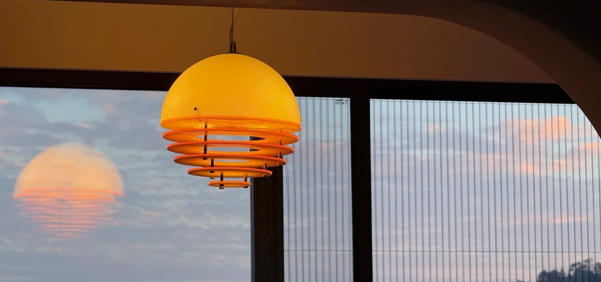 Zachodząca lampa wisząca o zachodzie słońca świecąca w oknie