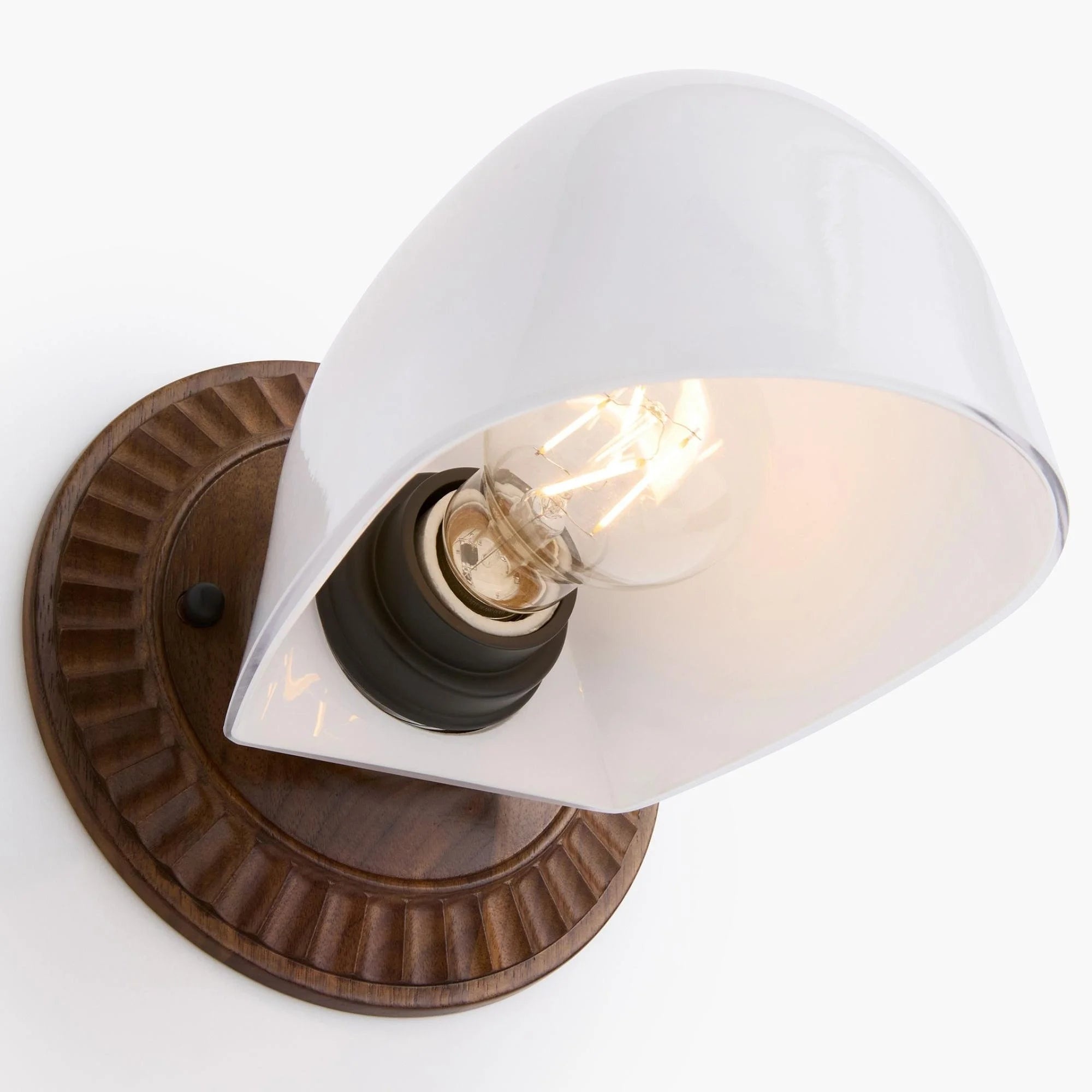 The curved white glass shade and fluted fixture create a sleek, cohesive look