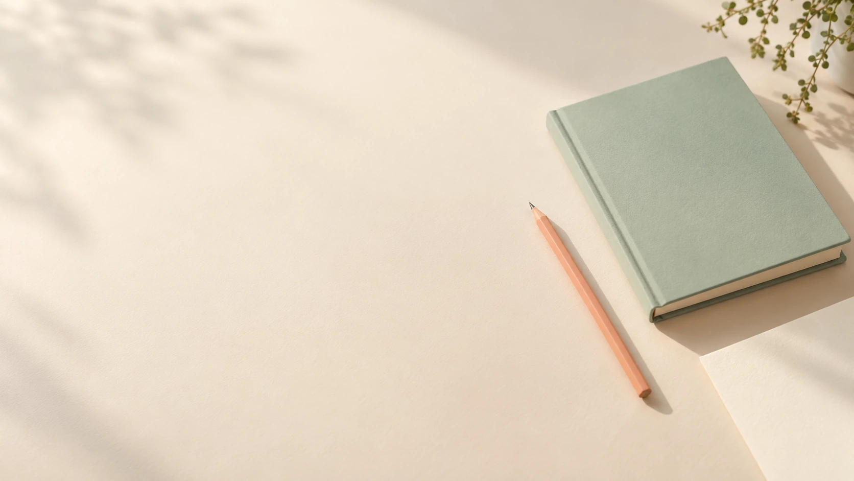 Mint notebook and peach pencil on an ivory creative deskslider_item_1