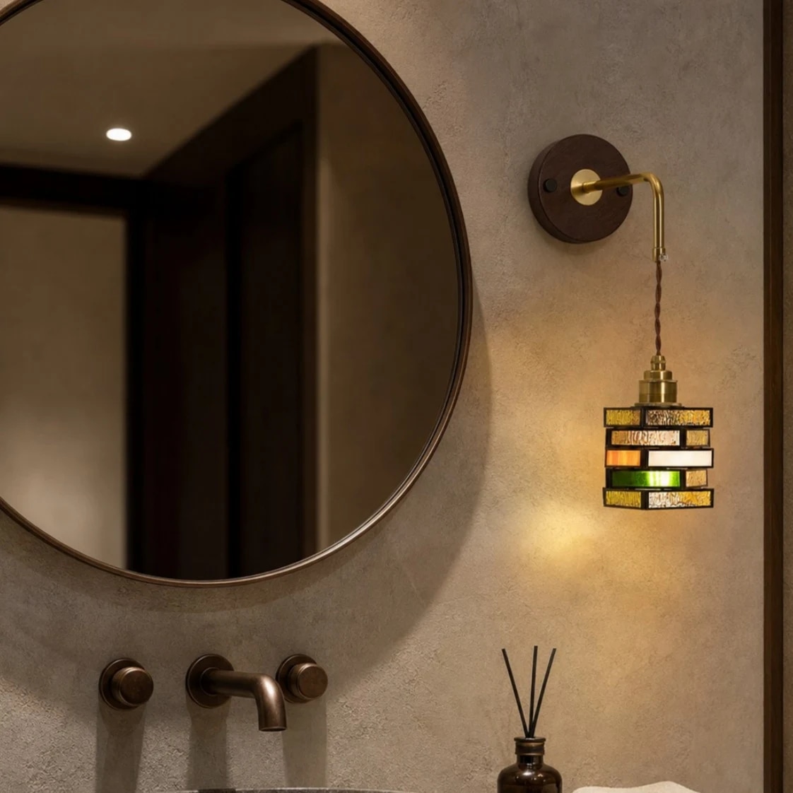 Applique murale en verre coloré à côté d'un miroir rond