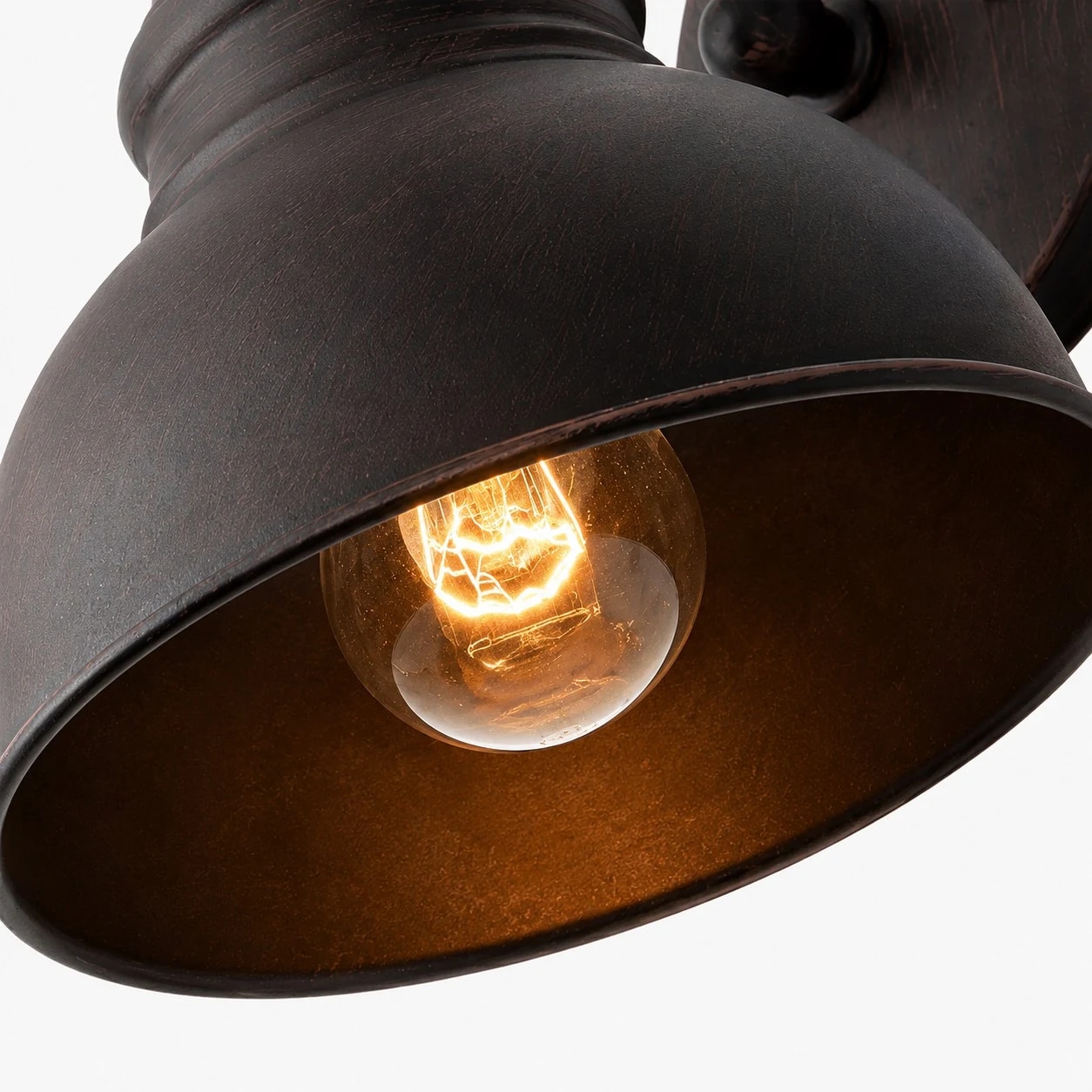 Visão aproximada da cúpula em tom bronze ferrugem e da abertura para lâmpada de luz quente.