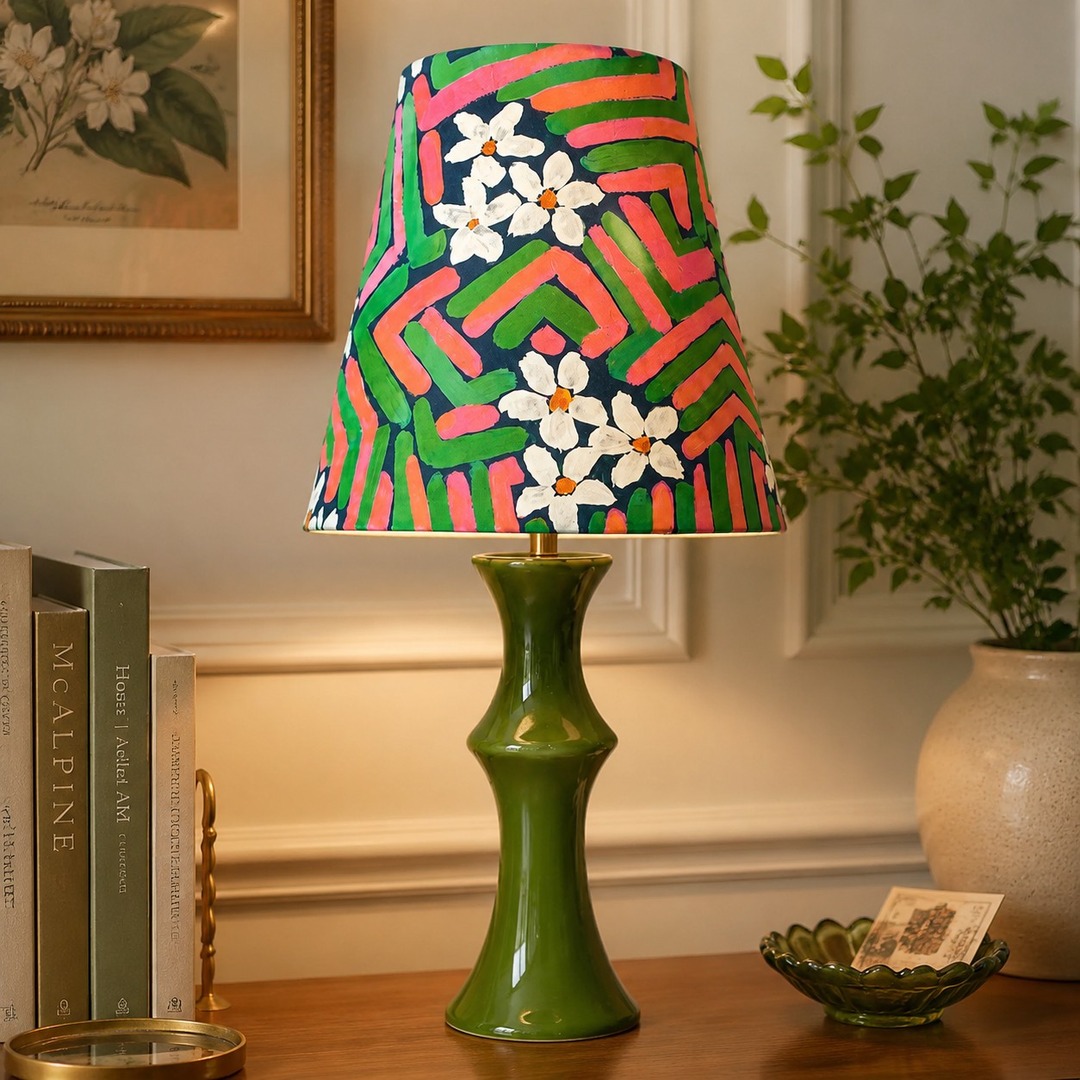 Roze en groene tafellamp die gloeit naast ingelijste kunst aan de muur