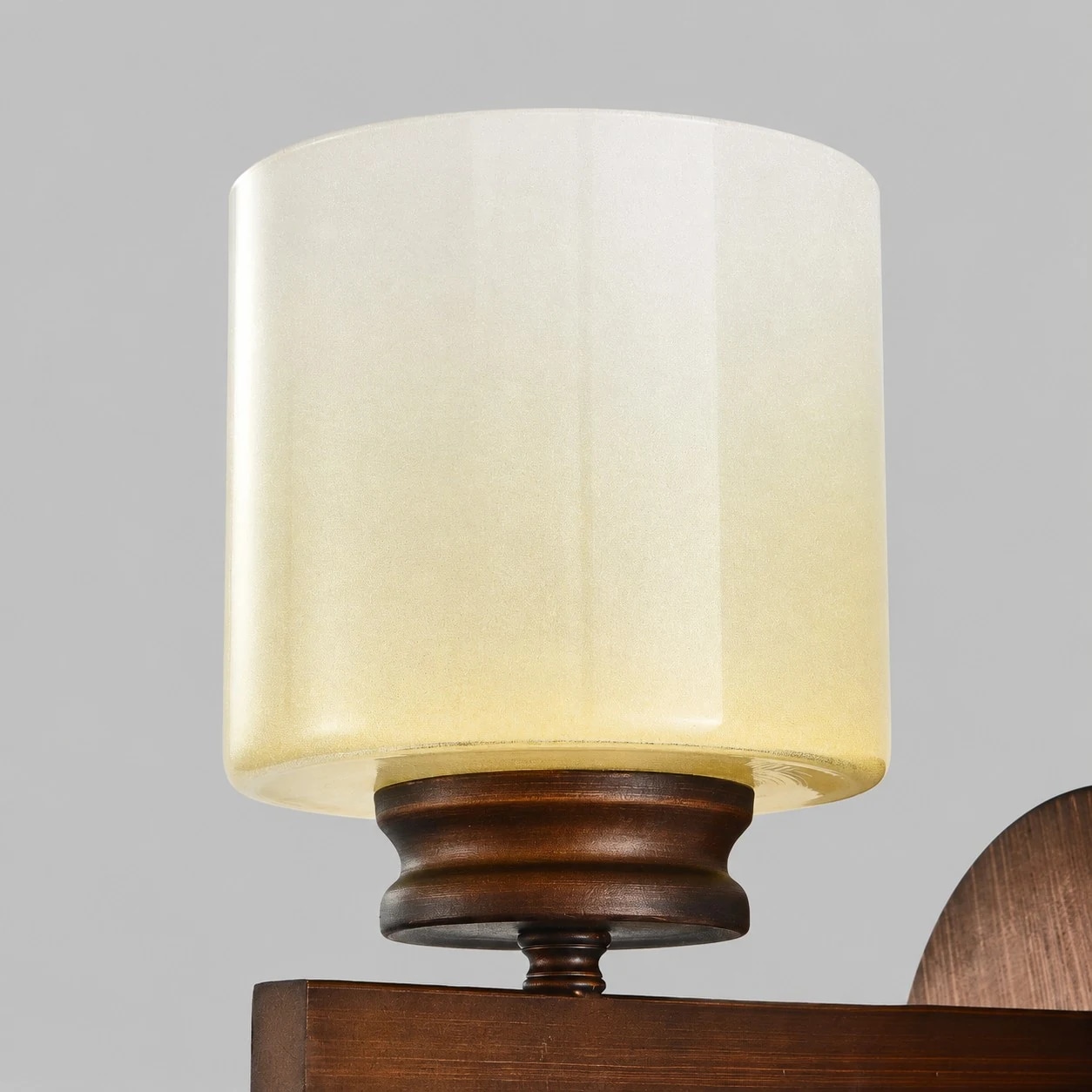 Detailopname van de albastkleurige, matglazen kap van de wandlamp.