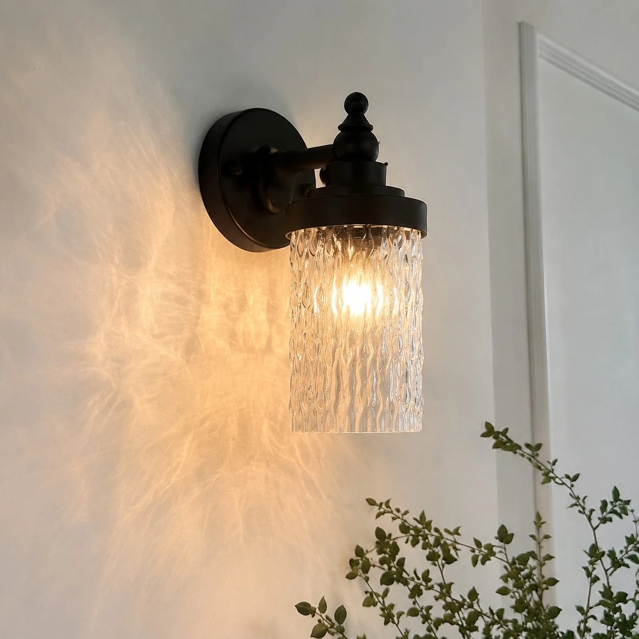Aplique de pared que proyecta una luz cálida en la esquina de un pasillo.