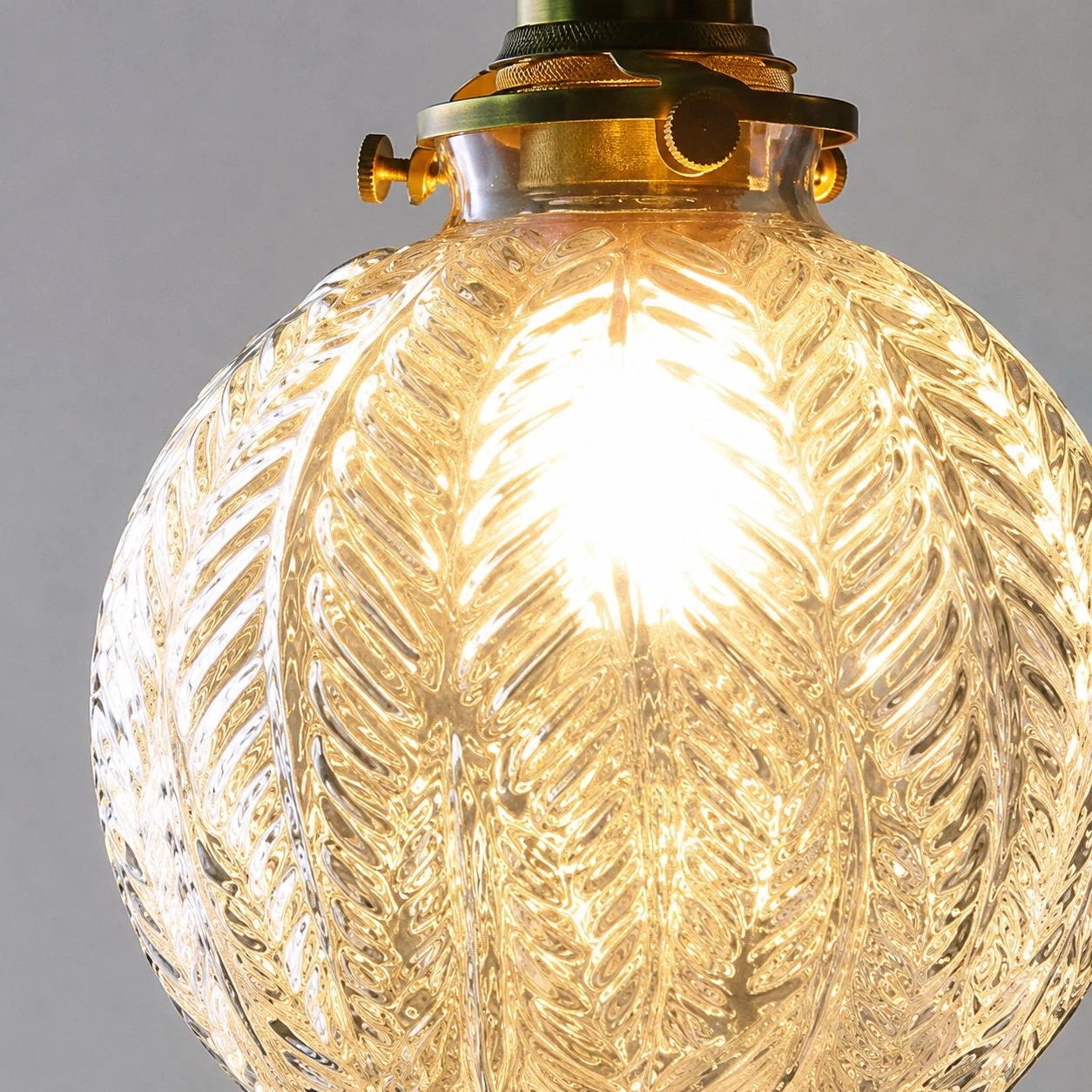 Abat-jour suspendu en verre transparent côtelé avec lumière chaude de l'ampoule