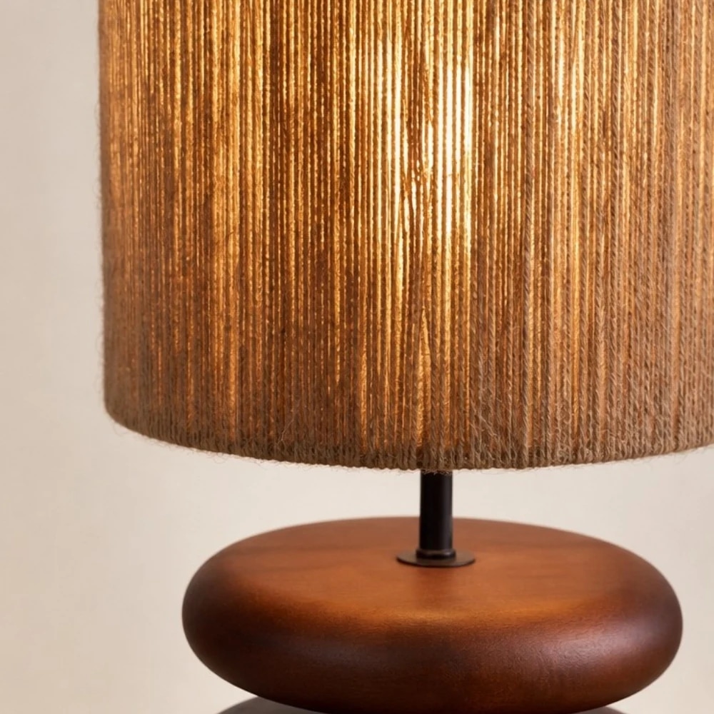 Lámpara de mesa con pantalla de cuerda de cáñamo de luz cálida sobre madera de nogal