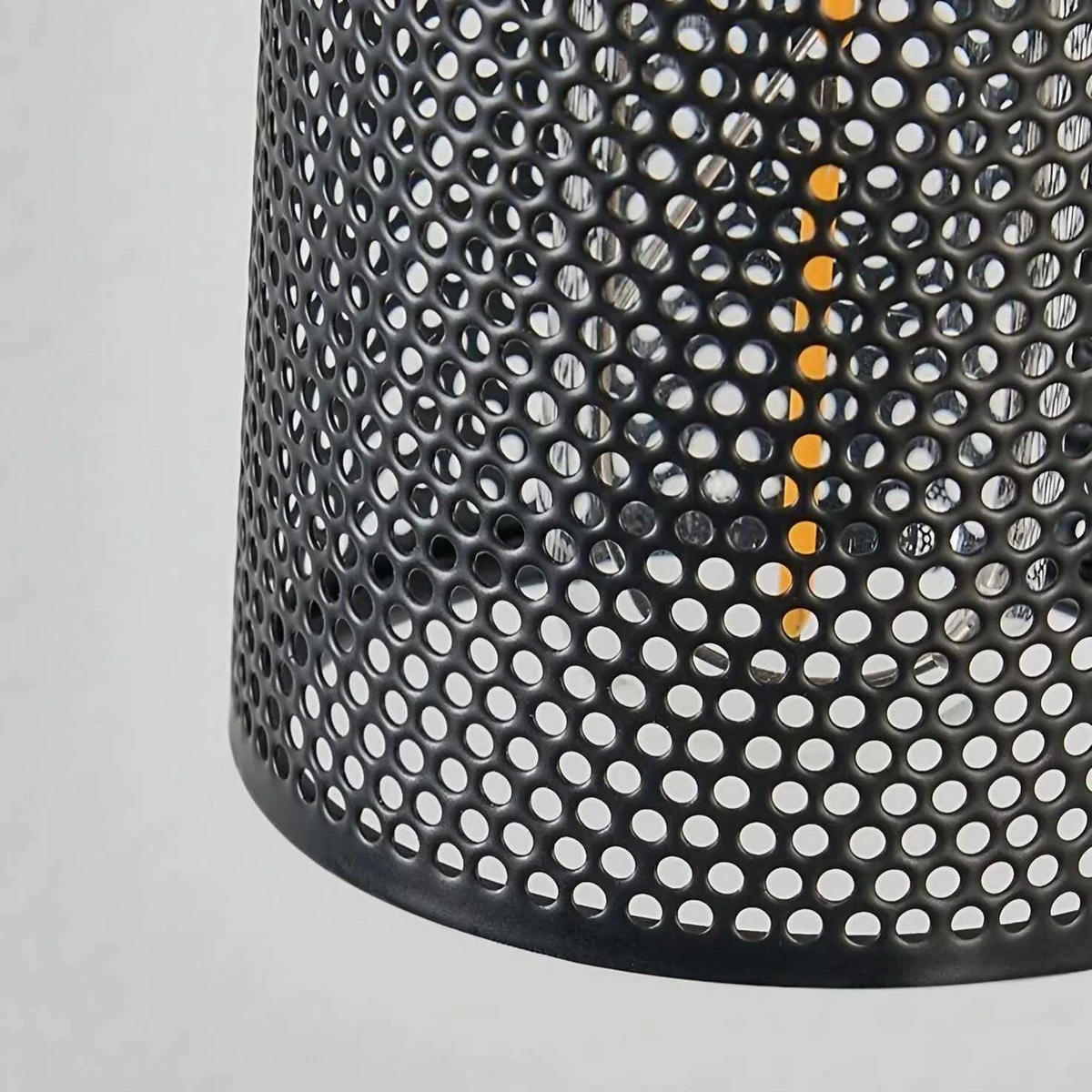 Close view of perforated black metal mesh shade