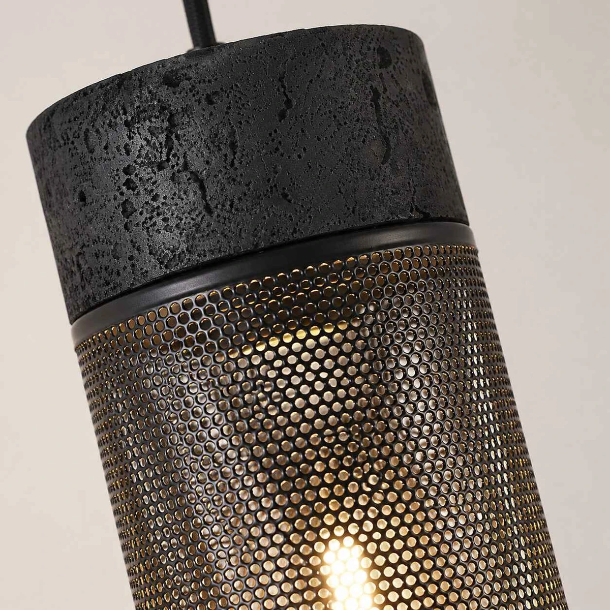 Close view of black travertine texture and warm bulb glow