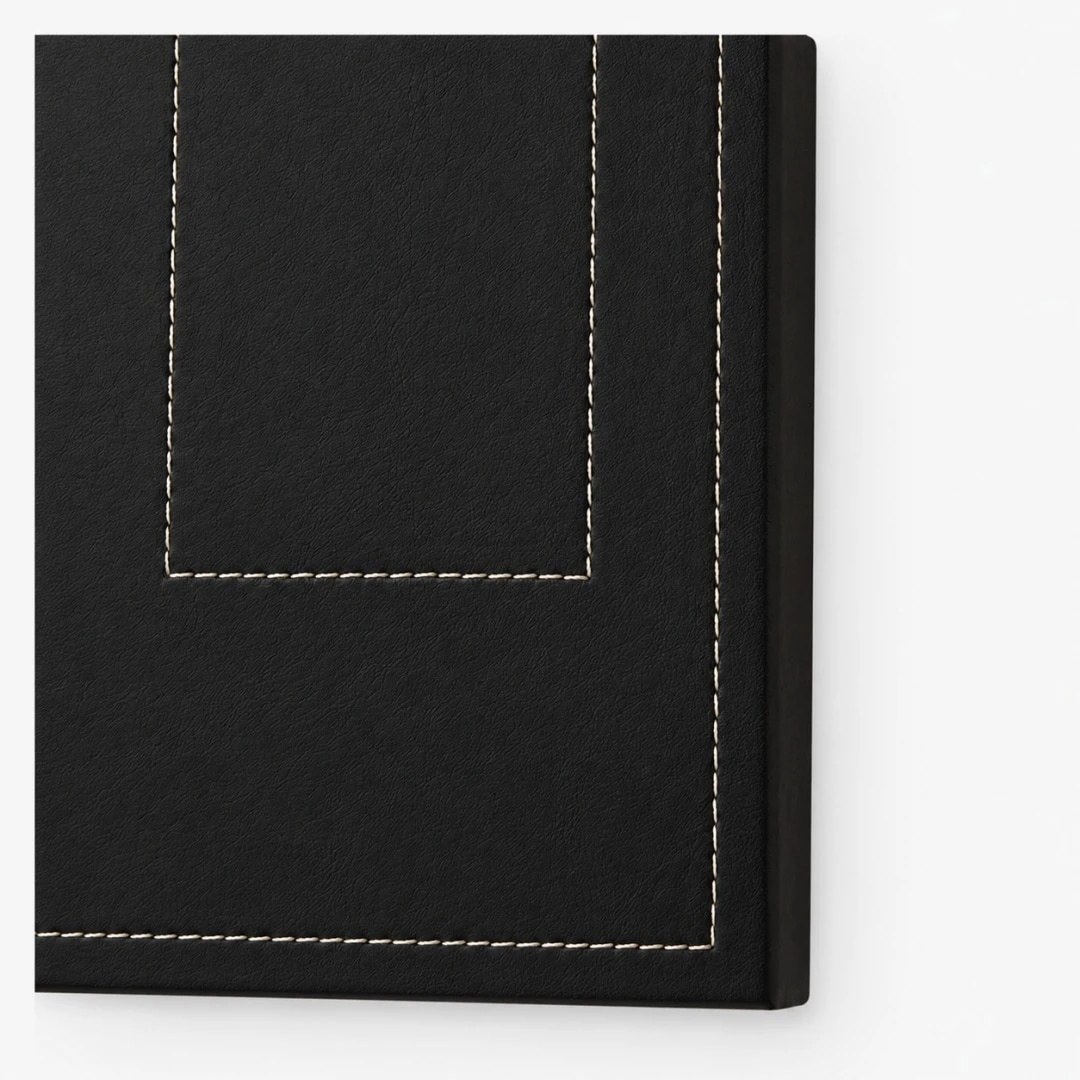 Närbild av mörk läderpanel och kontrastsömmar