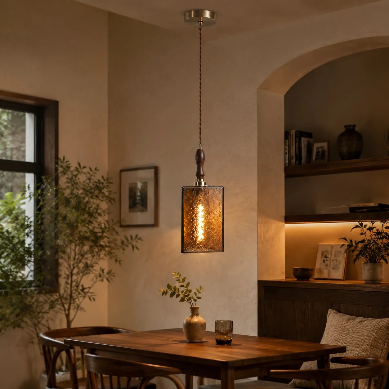Luminária pendente de vidro vintage instalada sobre uma mesa de jantar.