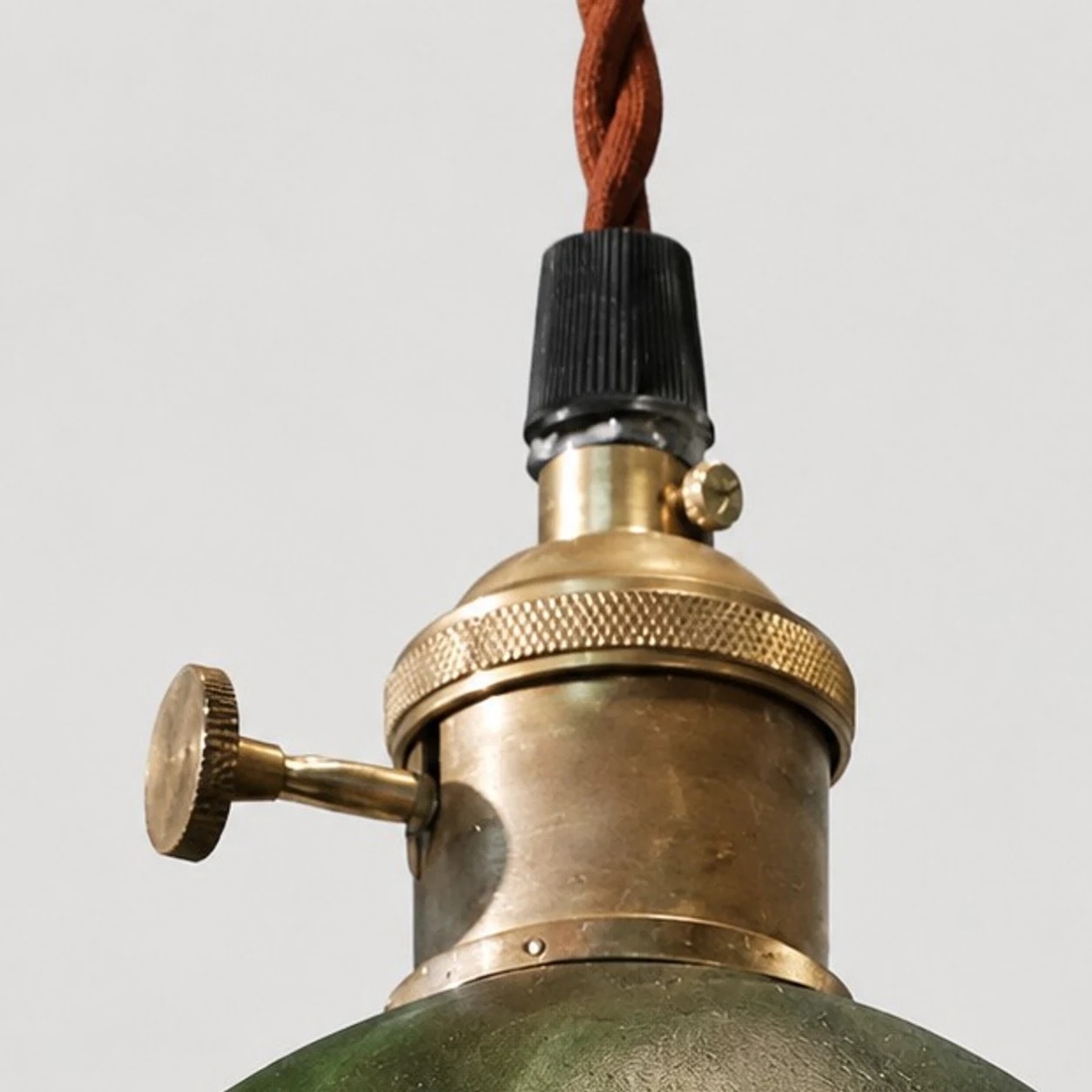 Detalj av mässingssockel för pendellampa