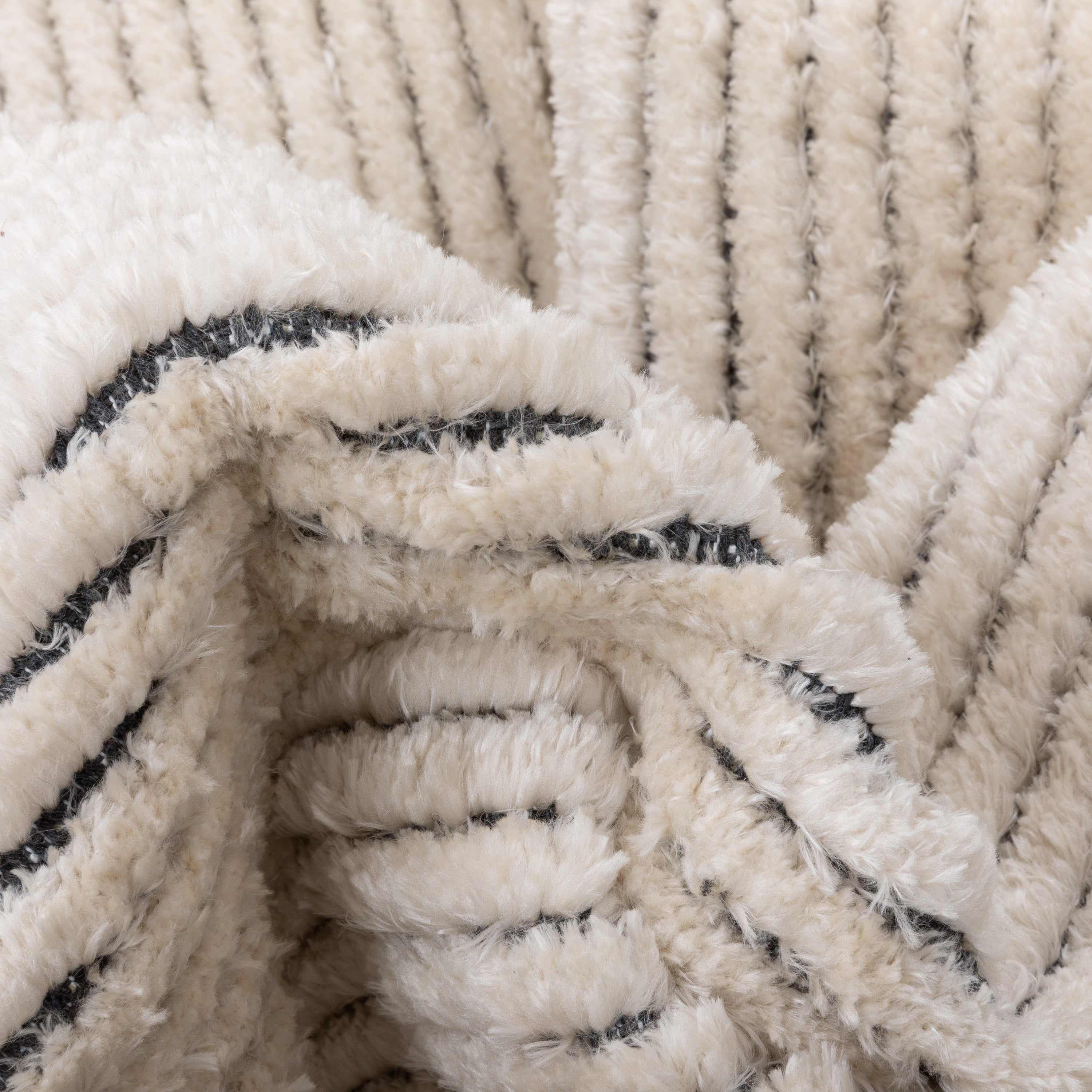 Adriel Tribal-Teppich mit festem Randmuster und elfenbeinfarbenem High-Low-Strukturflor