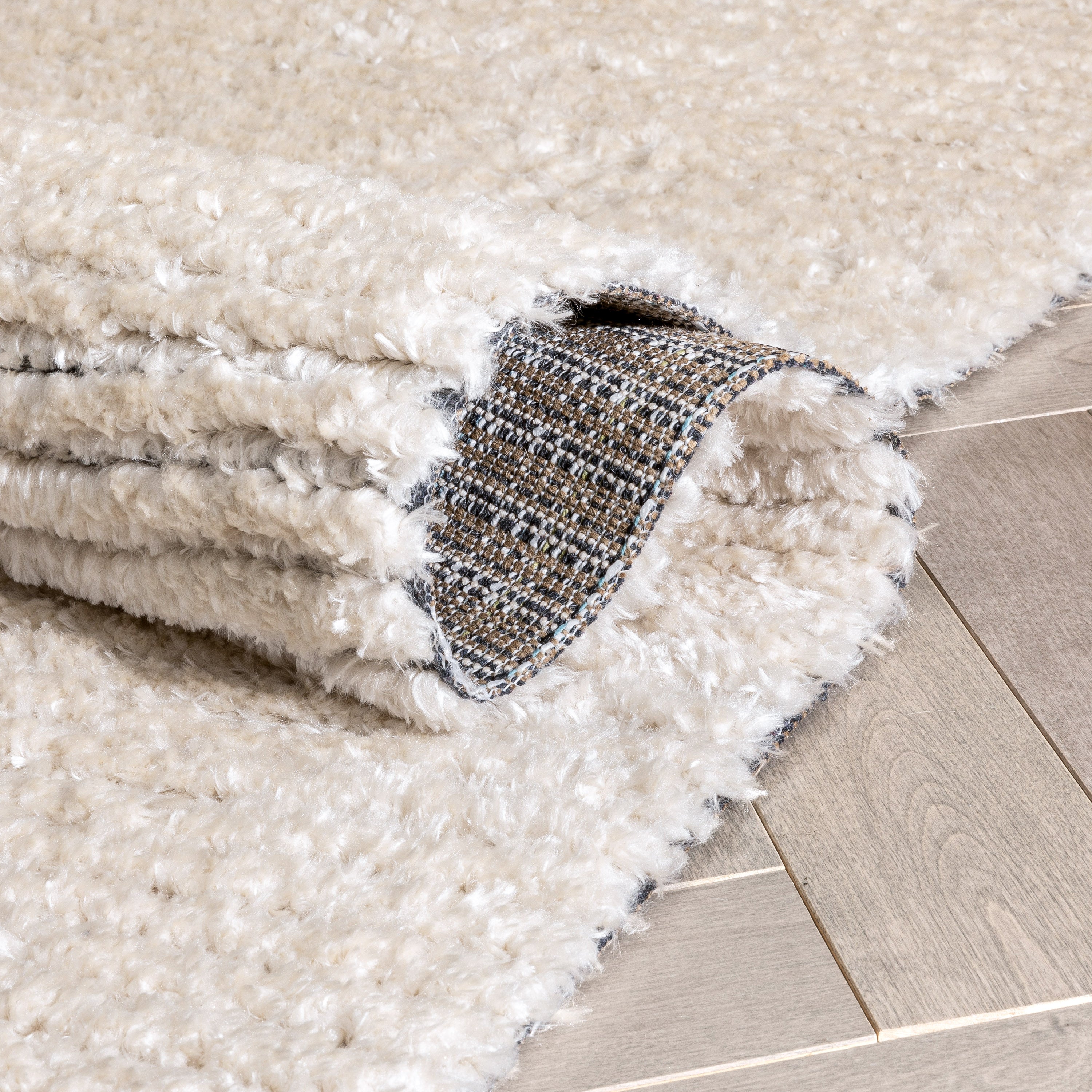 Adriel Tribal-Teppich mit festem Randmuster und elfenbeinfarbenem High-Low-Strukturflor