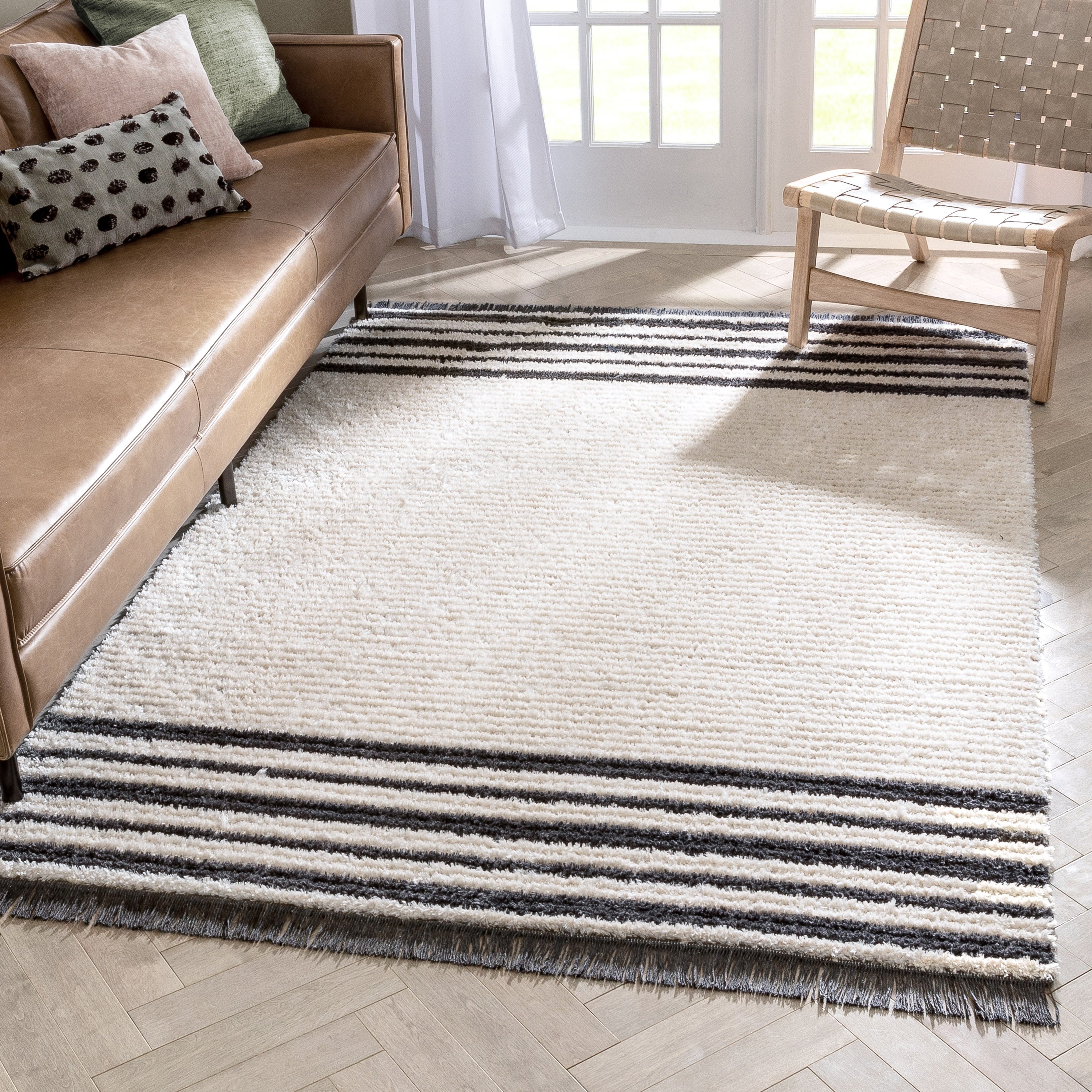 Adriel Tribal-Teppich mit festem Randmuster und elfenbeinfarbenem High-Low-Strukturflor