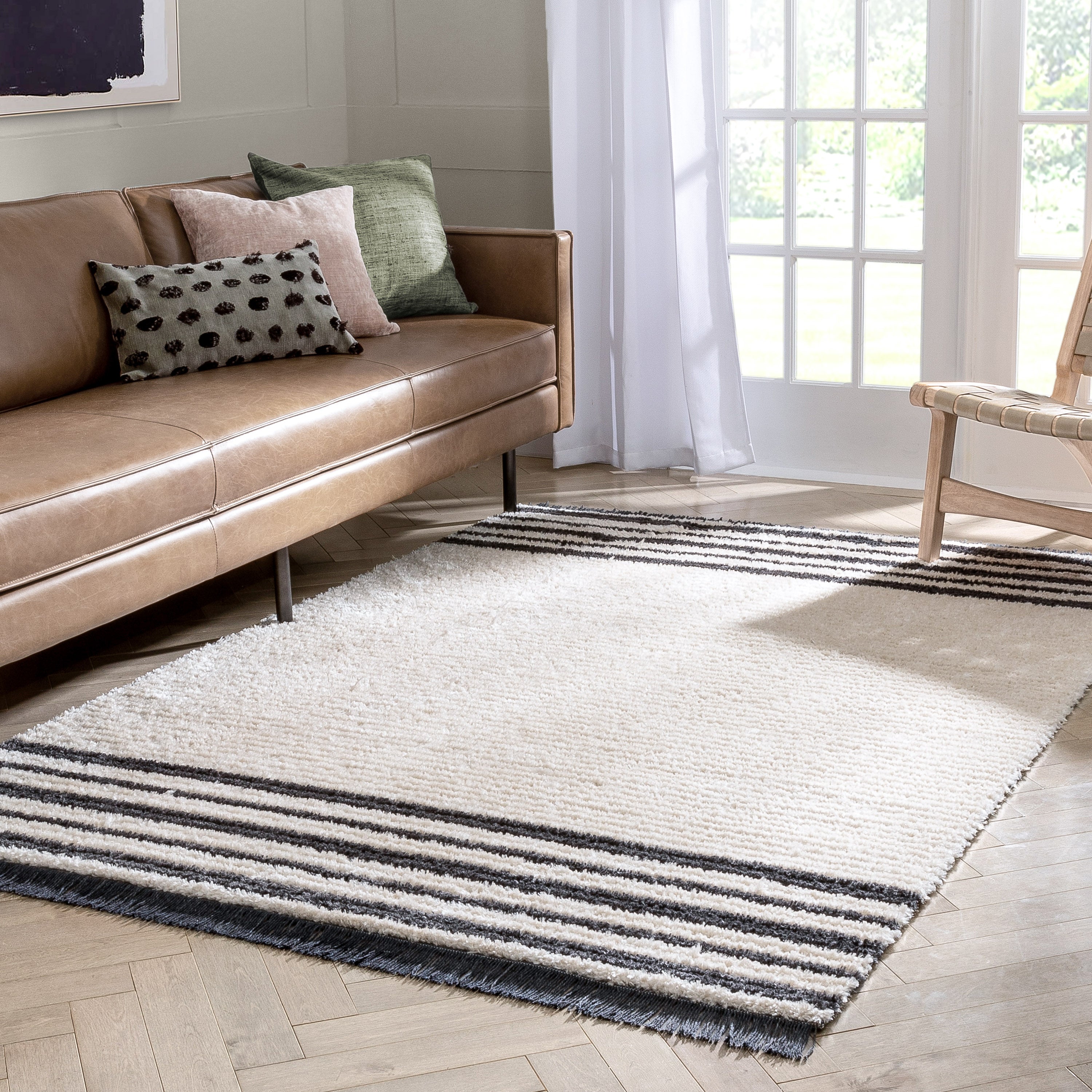 Adriel Tribal-Teppich mit festem Randmuster und elfenbeinfarbenem High-Low-Strukturflor