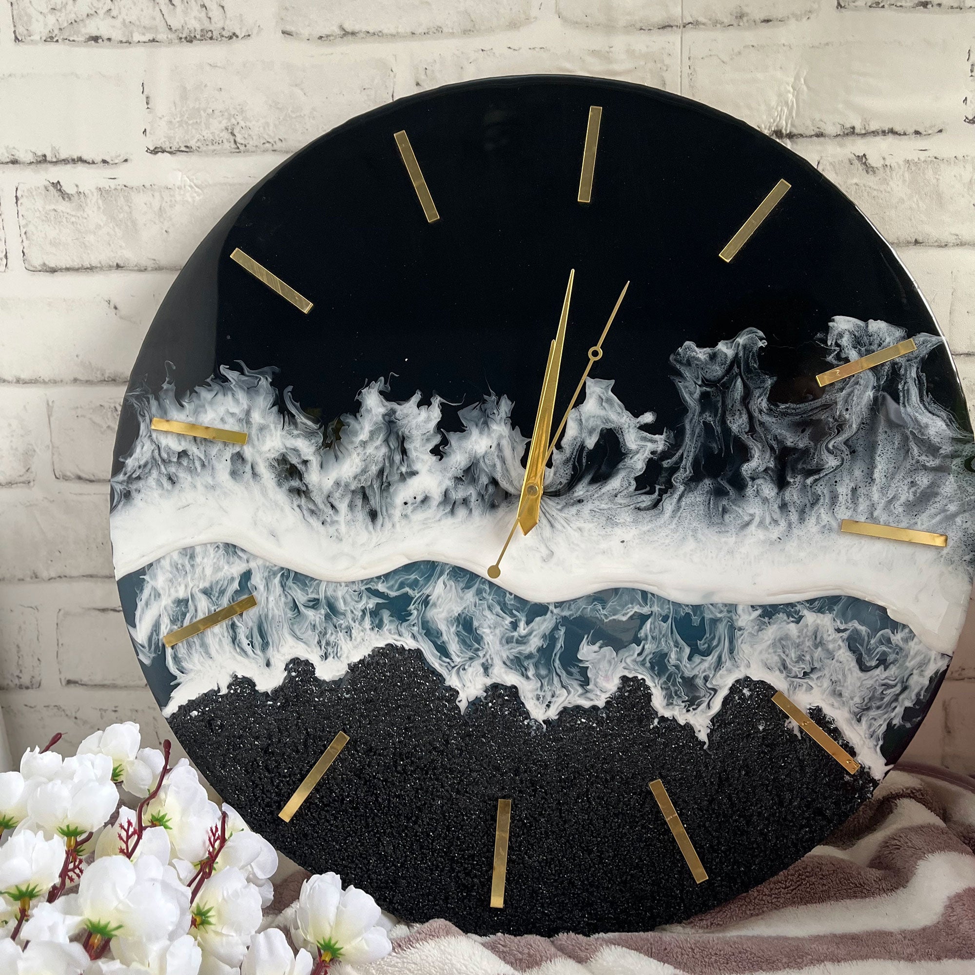 Black resin wall clock with white wave detail and gold-coloured markers
