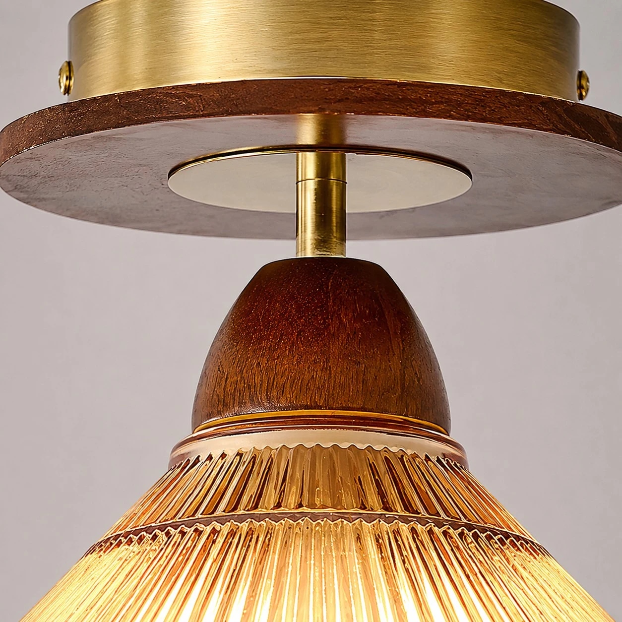 Ribbed shade, warm metal, and wood-tone contrast