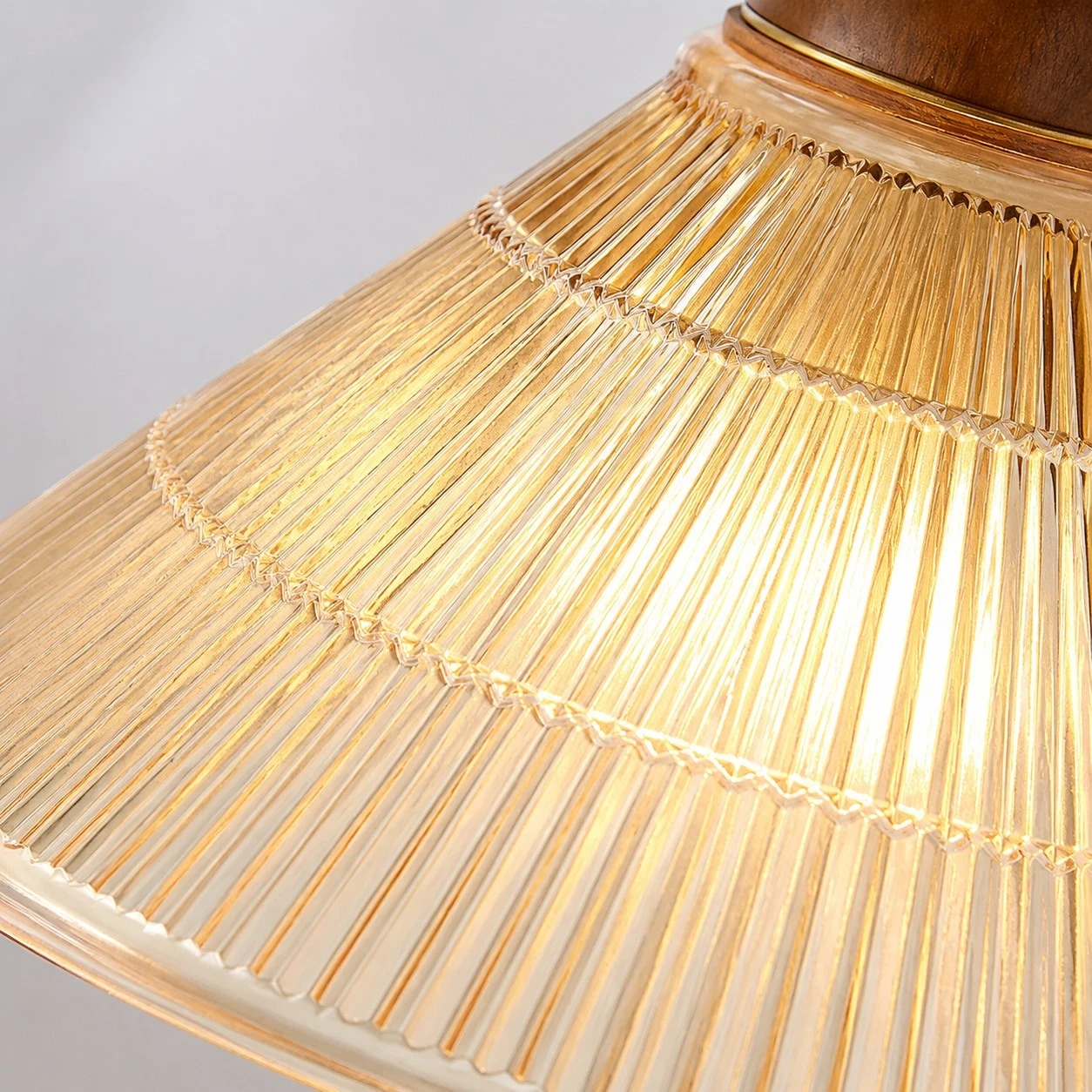 Ribbed shade, warm metal, and wood-tone contrast
