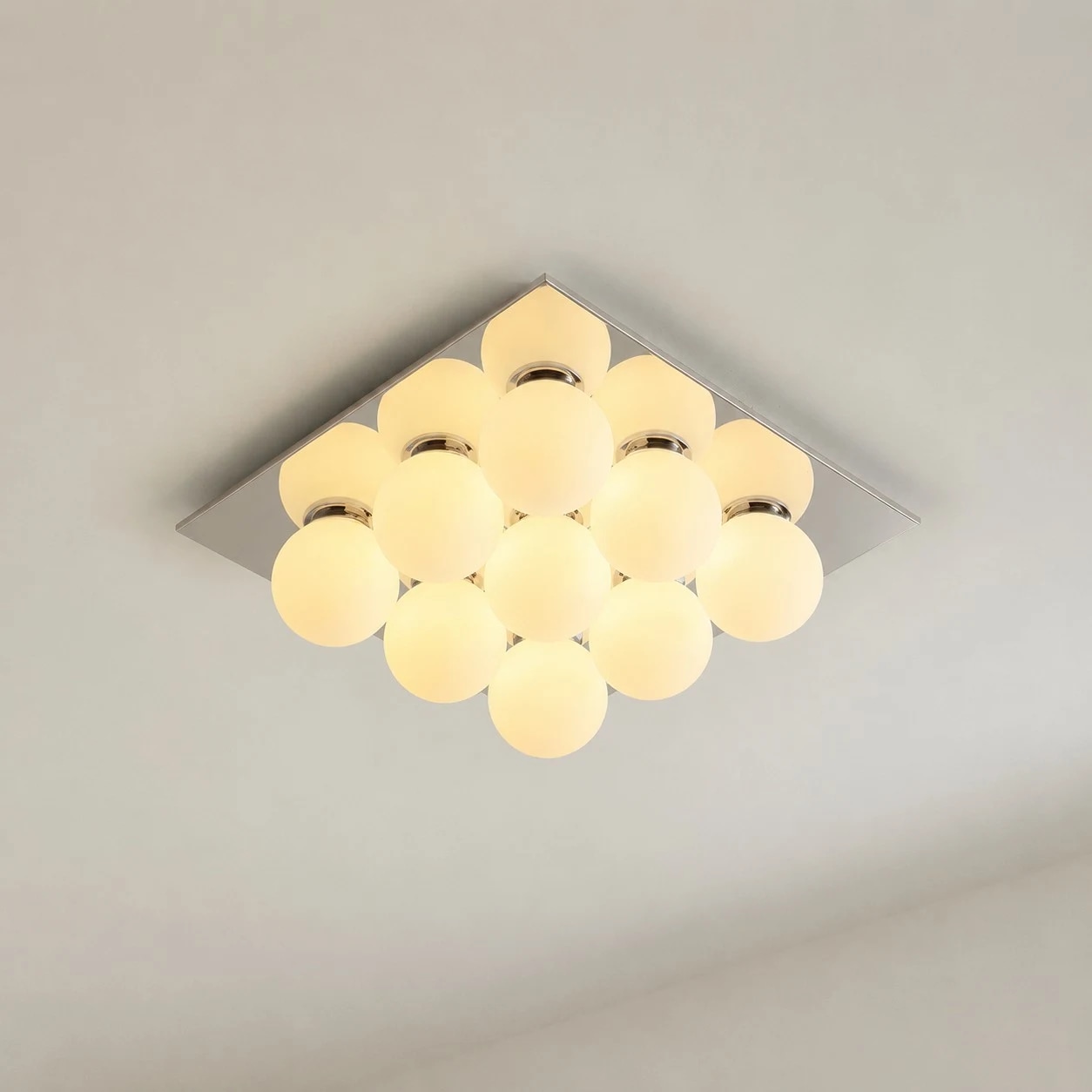 Lit nine-globe flush mount ceiling light with square chrome canopy