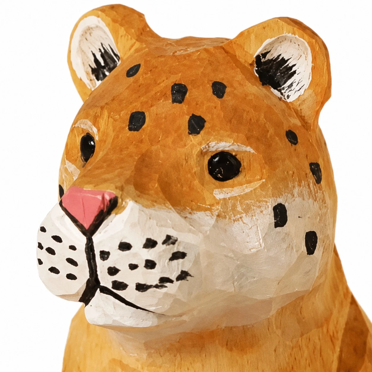 Cara de leopardo tallada a mano en madera con detalles de manchas.