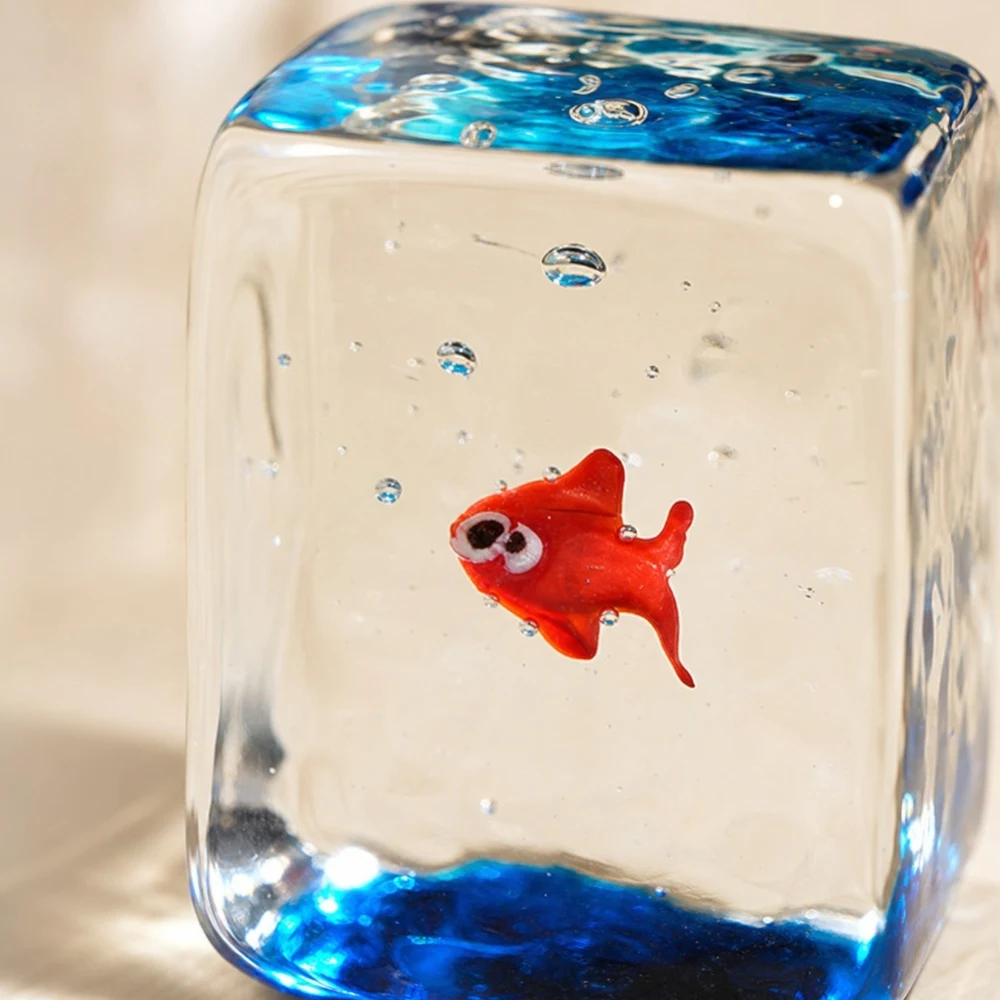Gros plan sur un ornement en forme de poisson rouge dans un bloc de verre transparent