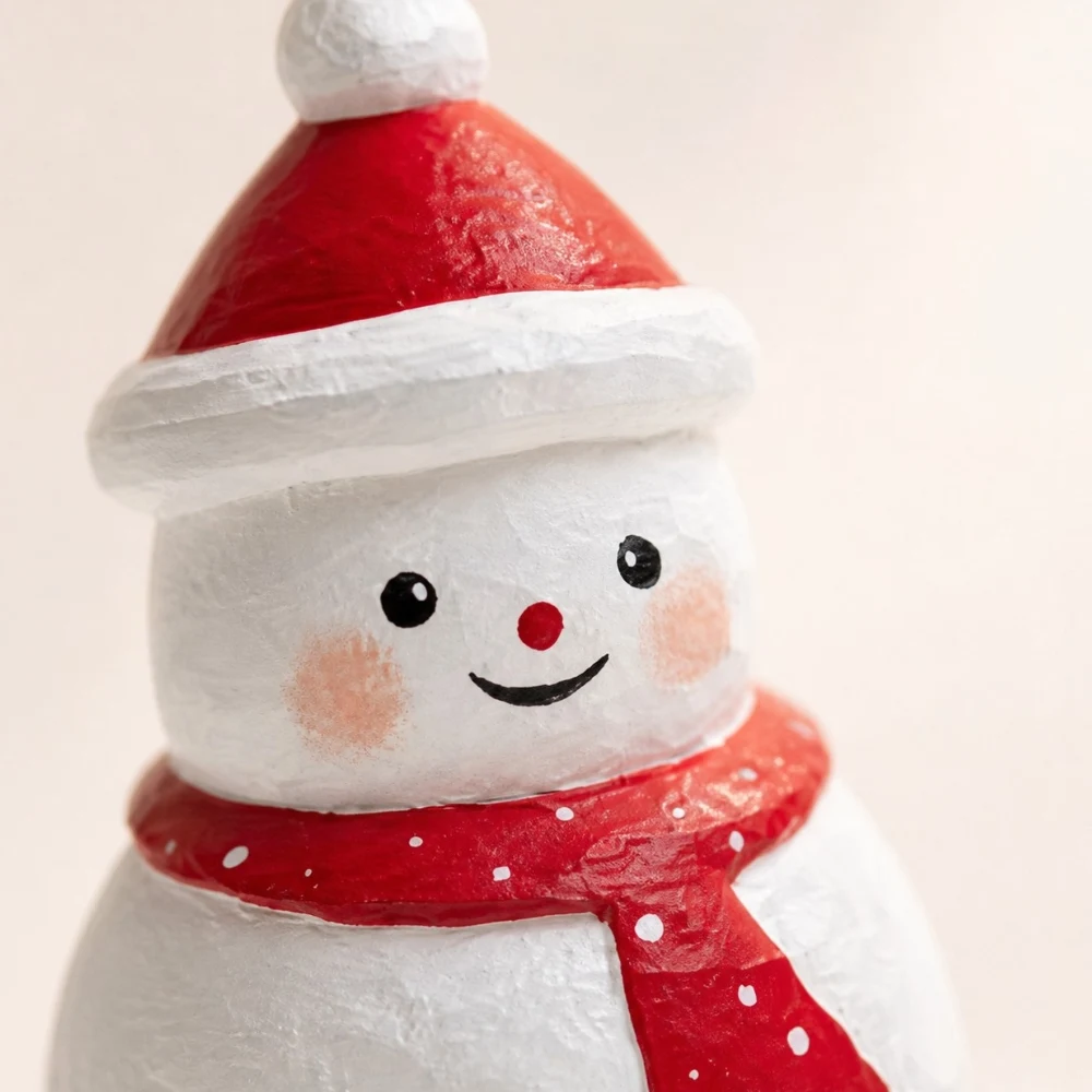 Gros plan sur le visage et l'écharpe d'un bonhomme de neige en bois fait main