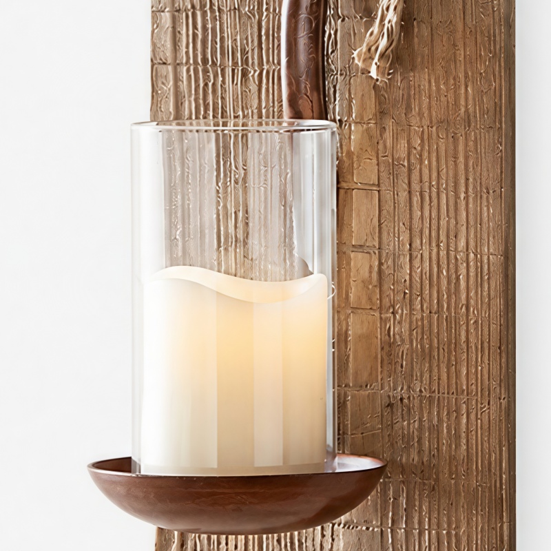Detailansicht des Glasschirms, der Kerze, des Eisenbechers und der strukturierten Holzrückwand.