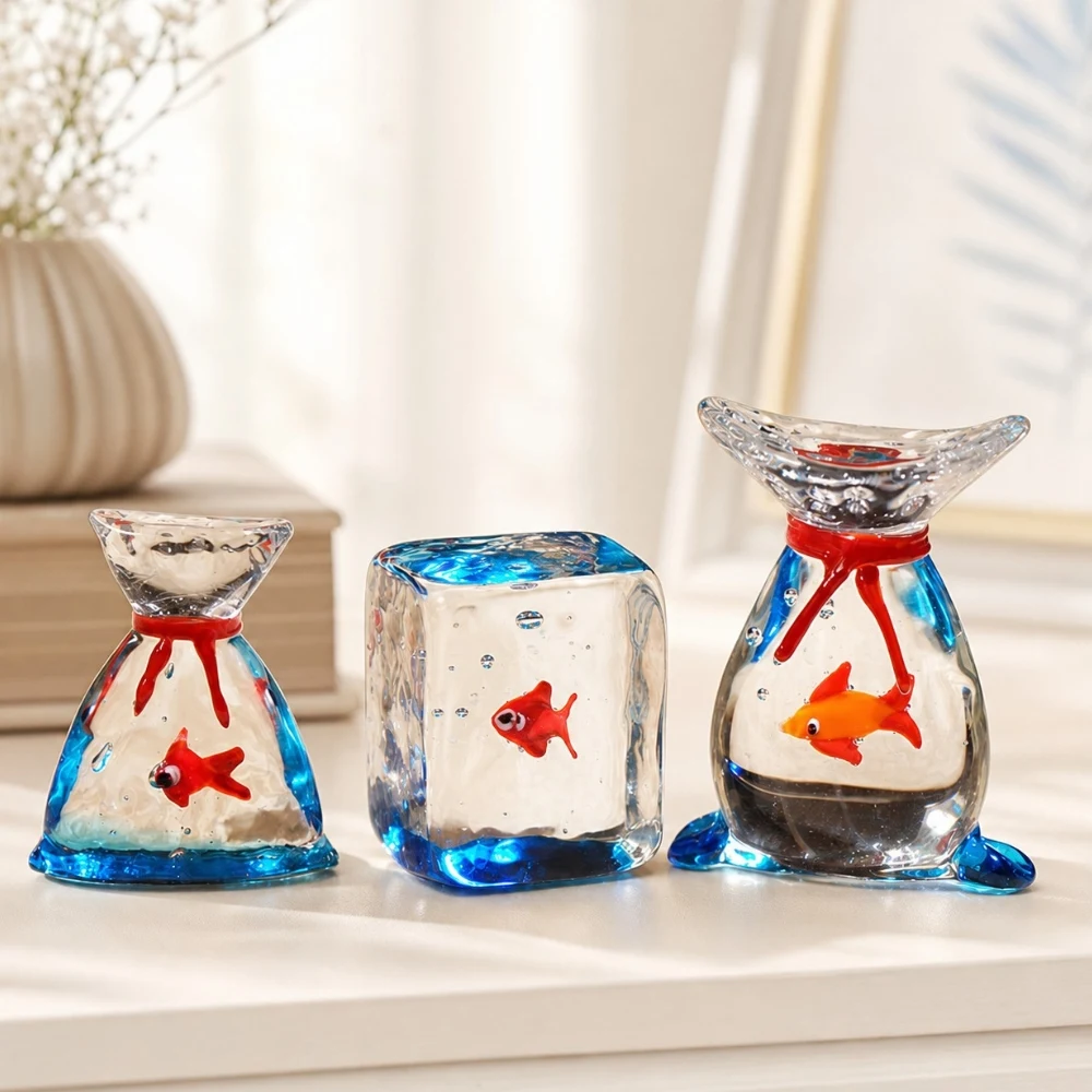 Trois figurines de poissons rouges en verre soufflé, exposées ensemble