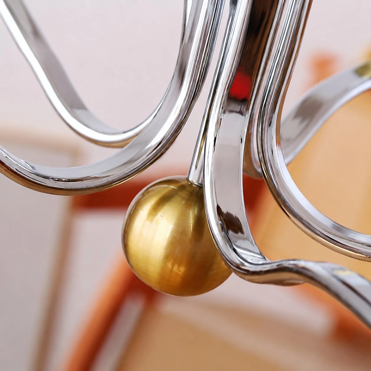 Visão aproximada do braço de metal polido e do detalhe em latão quente.