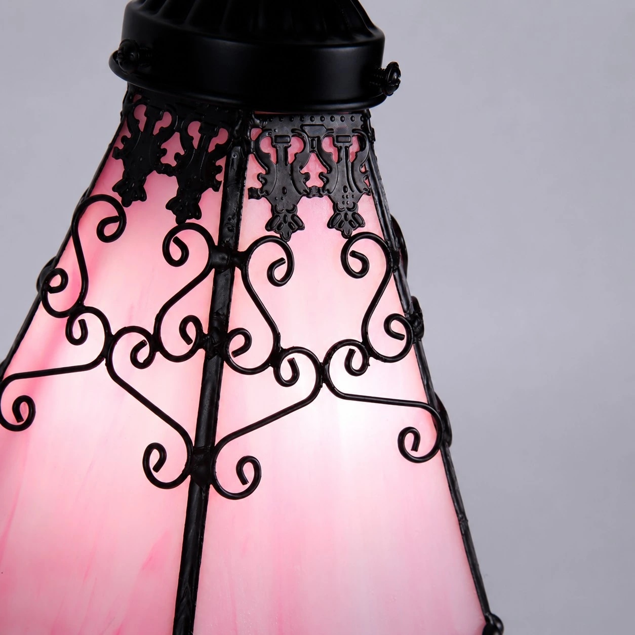 Close view of stained glass shade and black filigree frame