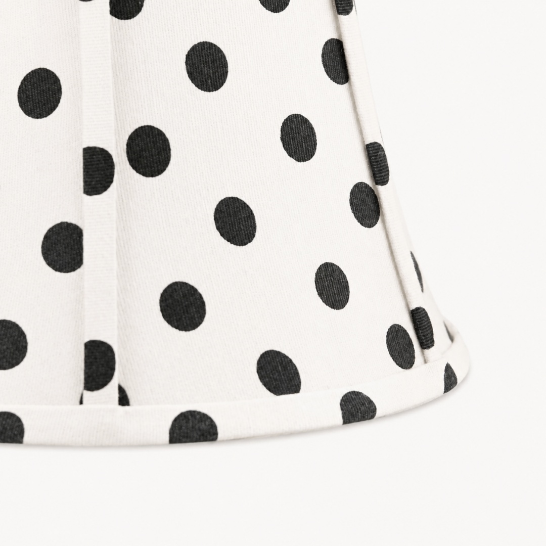 Close detail of fabric weave, black polka dots, and stitched shade edge