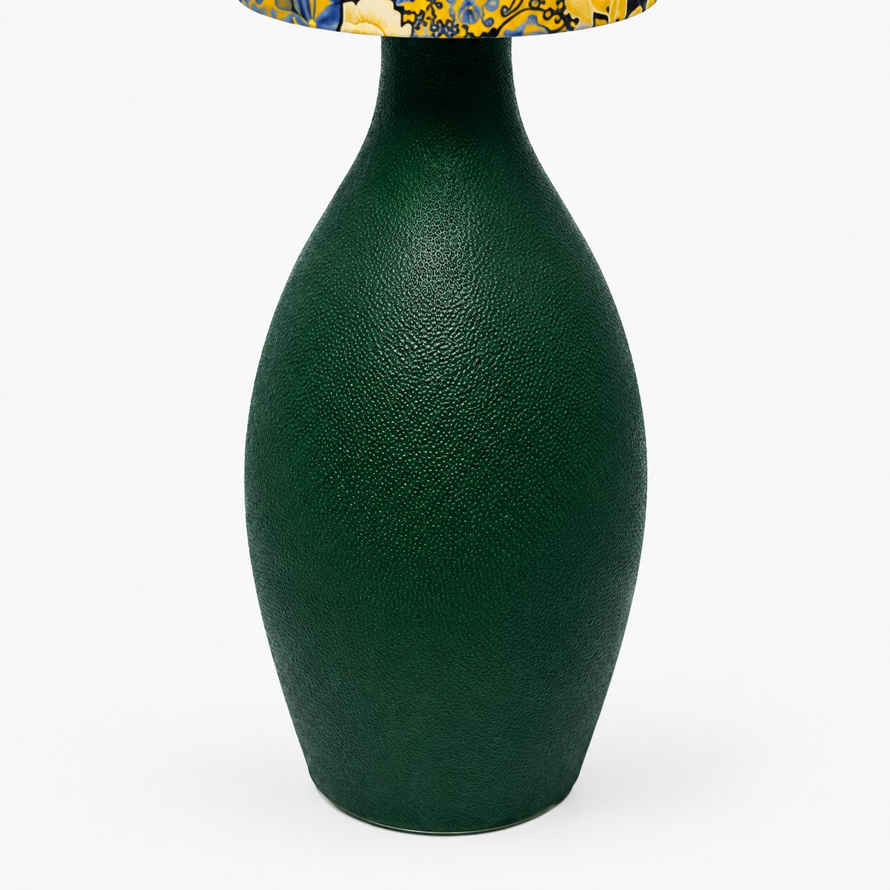 Detailní pohled na tmavě zelenou tvarovanou základnu lampy