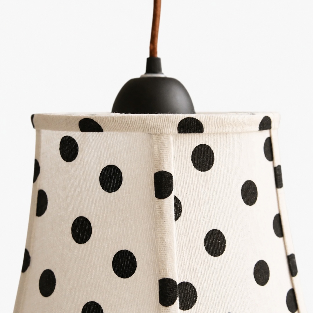 Close detail of pendant top cap, cord, and fabric shade structure