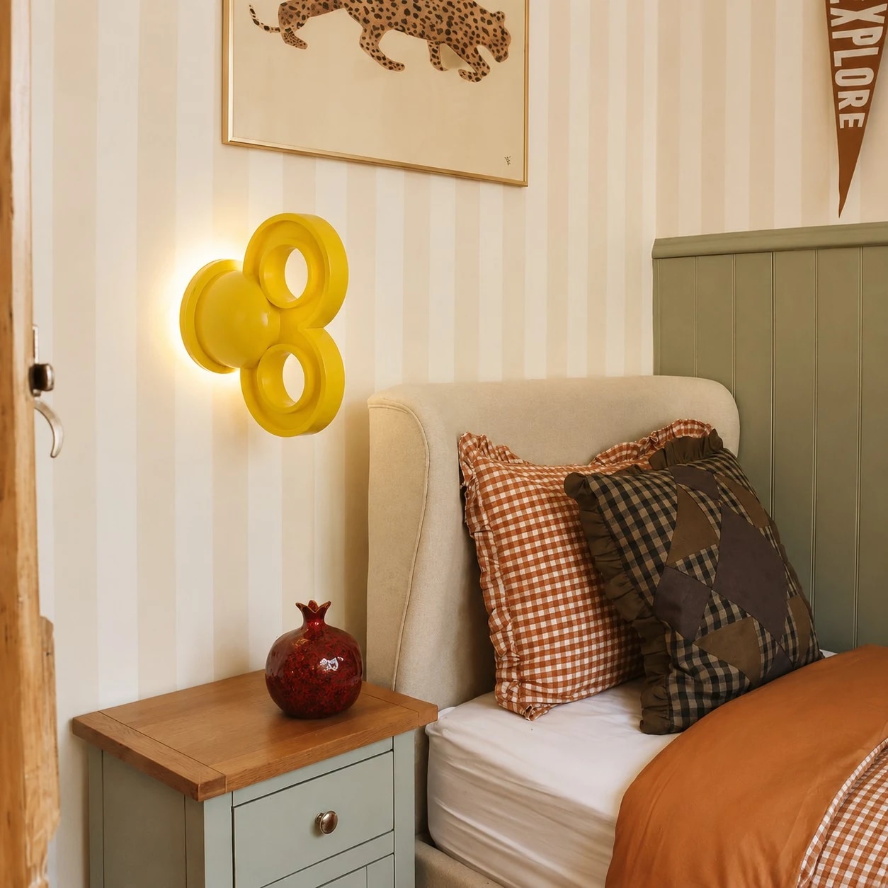Aplique amarelo ao lado de uma cama em um quarto aconchegante
