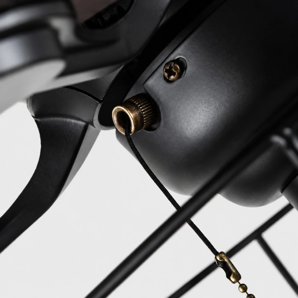 Visão aproximada do motor preto do ventilador de teto e detalhe da corrente de acionamento.