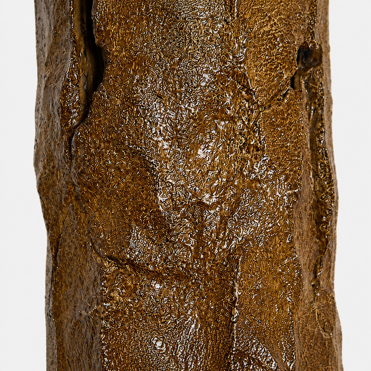 Detalhe da textura de um aplique de parede em resina inspirada na casca de árvore.