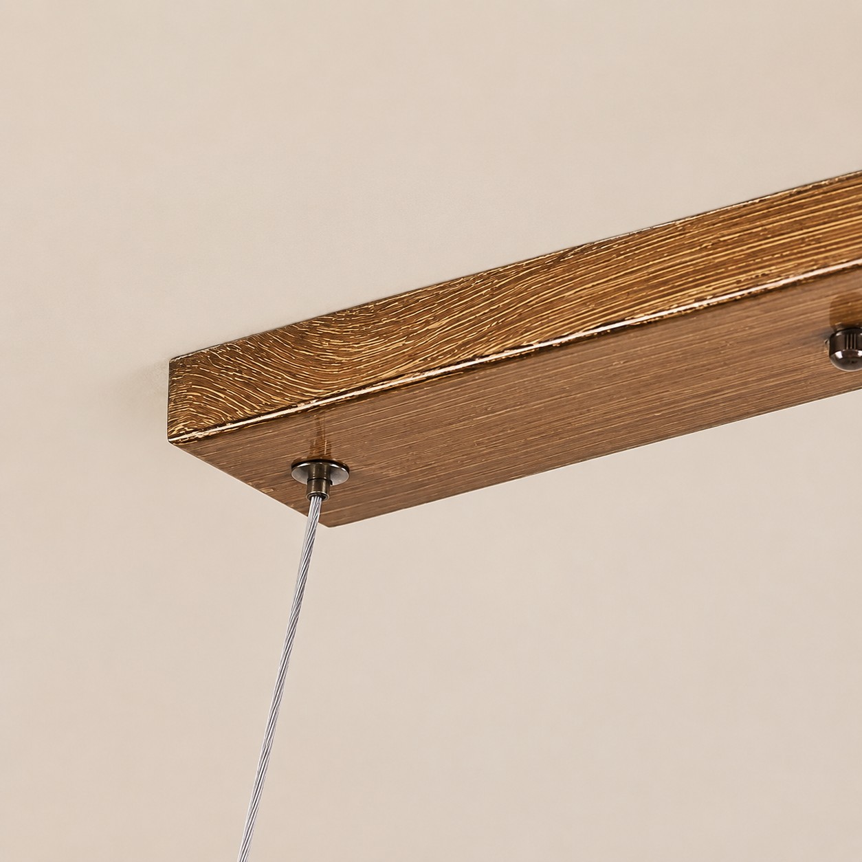 Detalhe de luminária pendente linear em resina na cor madeira para teto