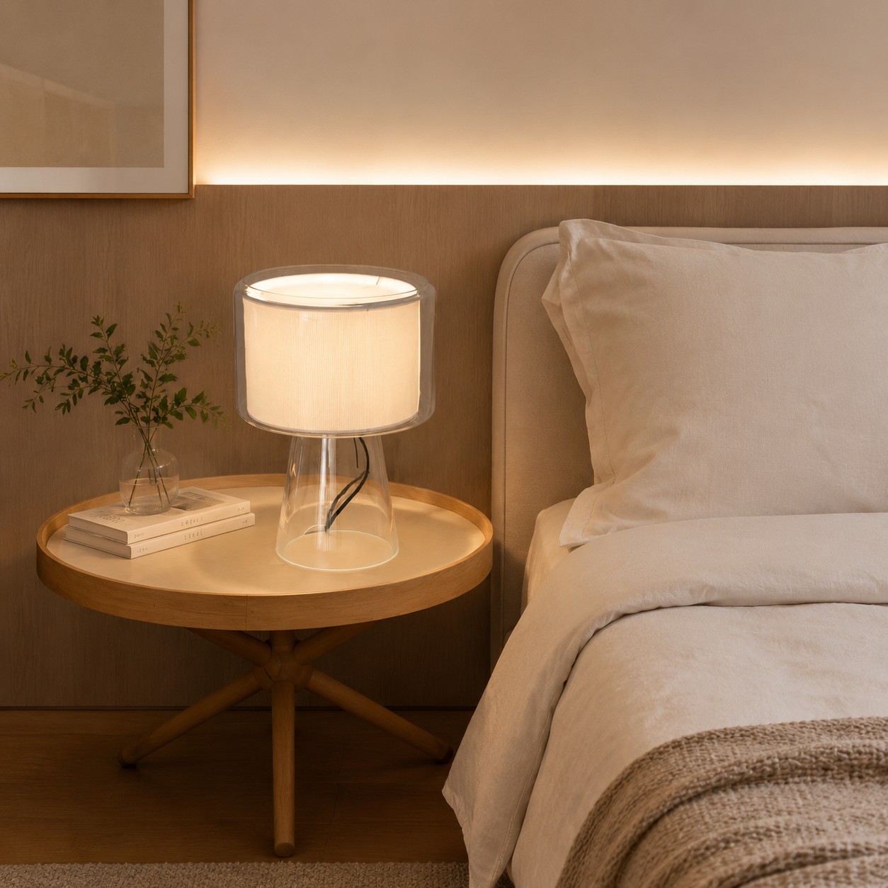Lampada da tavolo in vetro naturale con paralume in tessuto, ideale per un ambiente intimo.