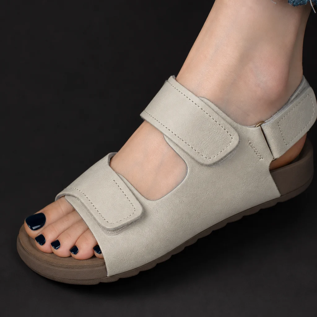 Close-up of ivory sandal straps stitching and taupe sole