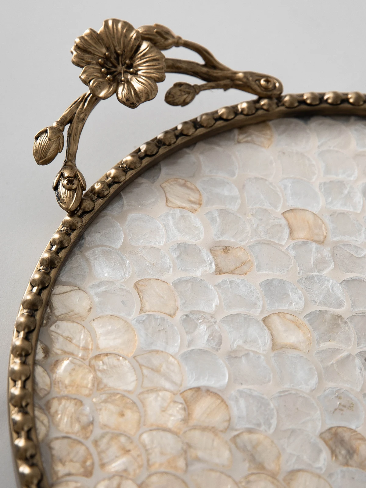 Close view of shell inlay, bead rim, and antique-gold floral handle