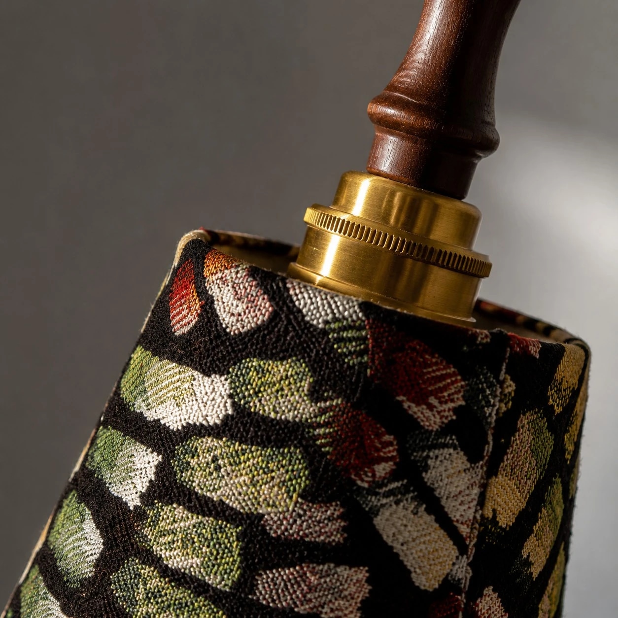 Close view of the brass-tone fitting and patterned fabric shade