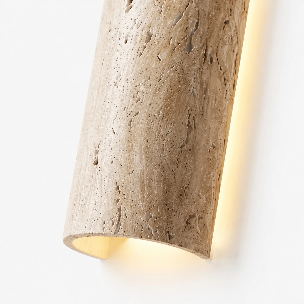 Close view of travertine linear LED wall light with warm edge glow