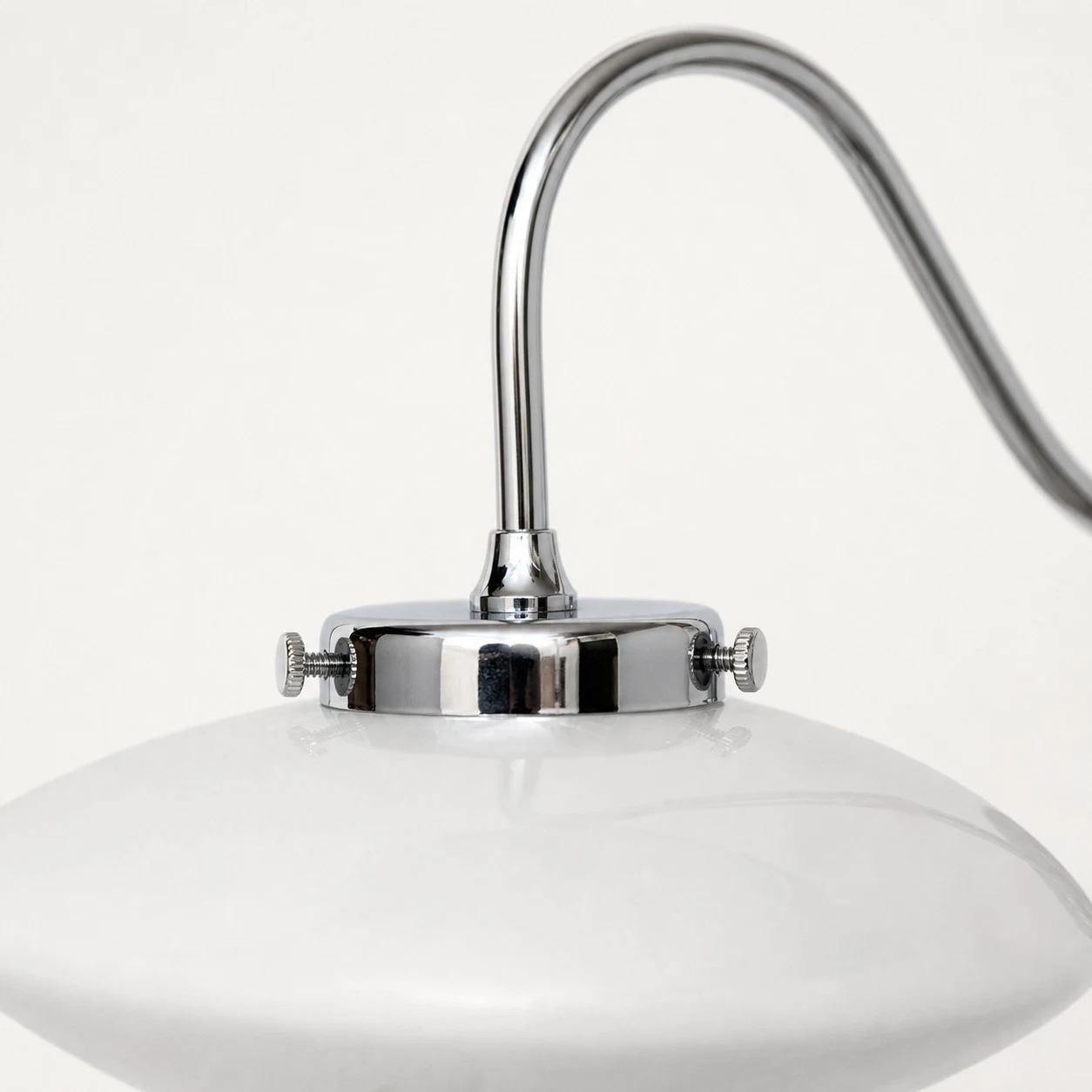 Glass shade and chrome hardware detail of the wall sconce