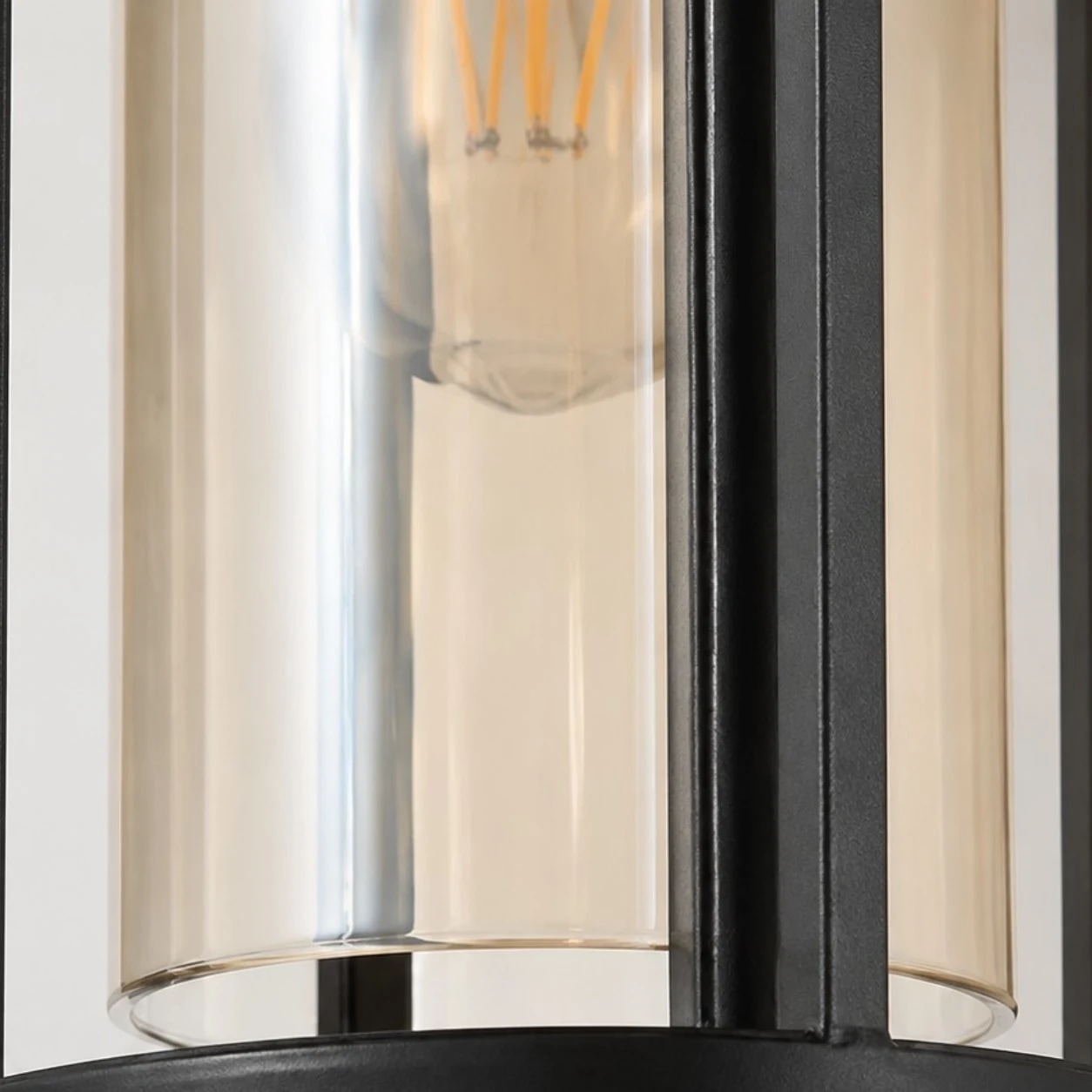 Close-up of amber glass cylinder and warm E27 bulb inside the lantern